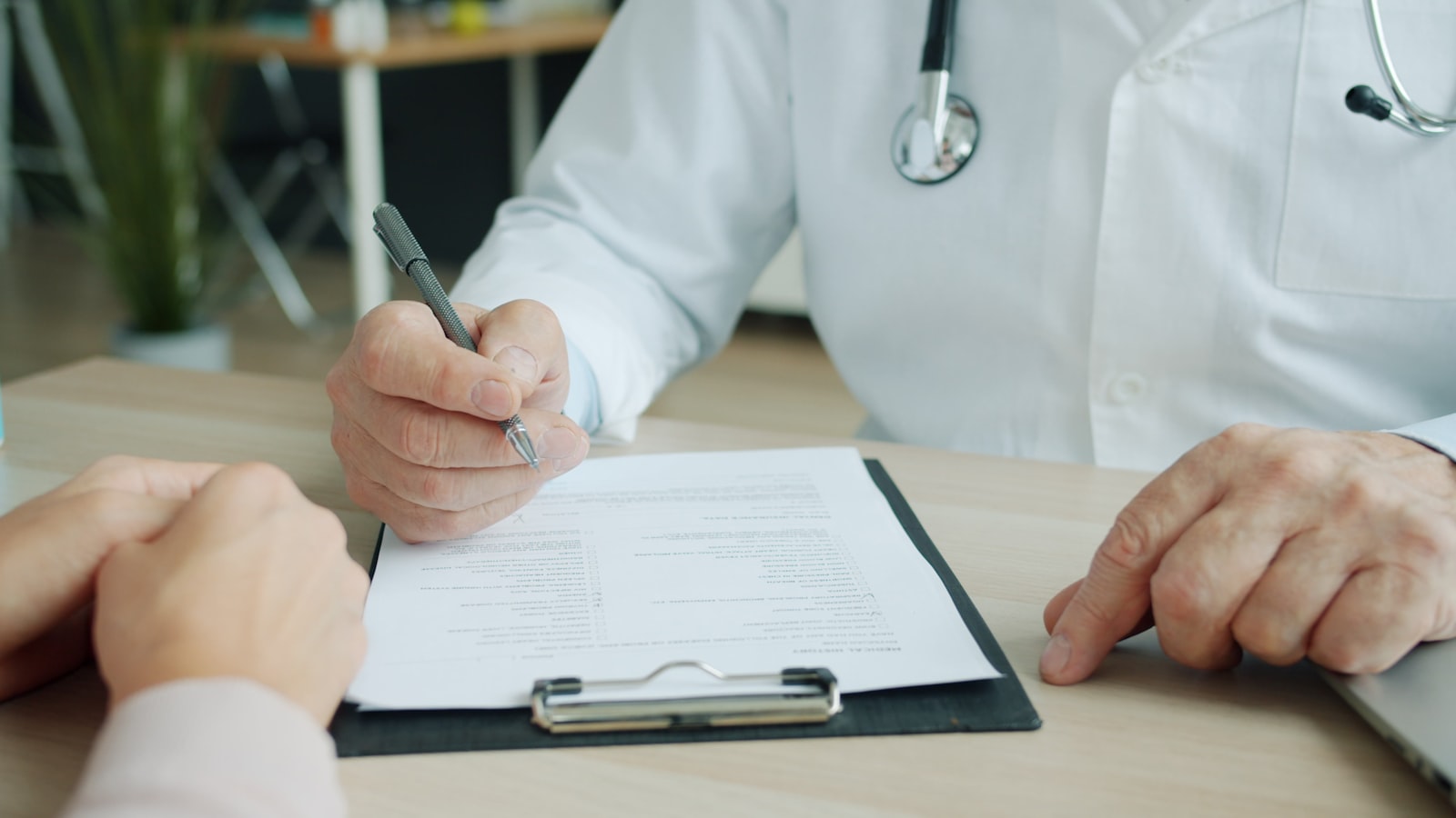 Un médico rellenando un historial médico durante una consulta